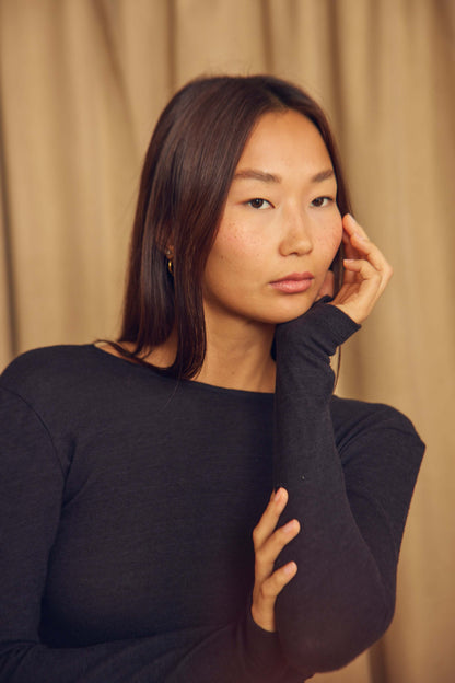 Model wearing a Black Wool Wrap Top with Thumb Holes, showcasing a stylish feminine look.