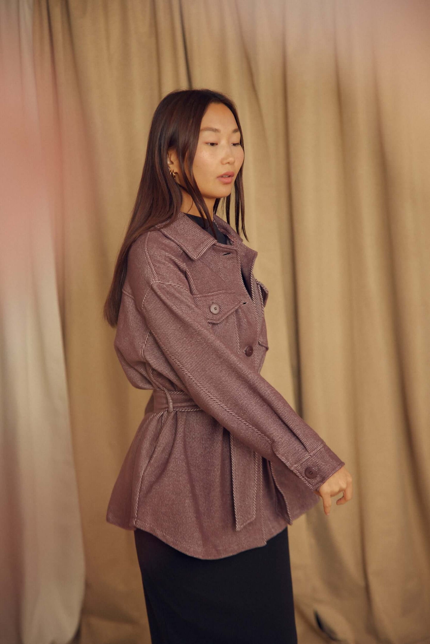 A model wearing the Cocoa Organic Cotton Shacket, featuring a relaxed silhouette and detachable waist tie.