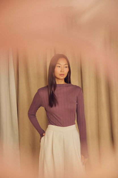 Model wearing Ecru Organic Cotton Wide Trousers with a fitted purple top against a soft backdrop.