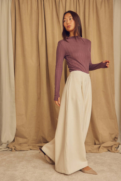 Model wearing Ecru Organic Cotton Wide Trousers with a fitted purple top, showcasing a stylish wide-leg silhouette.