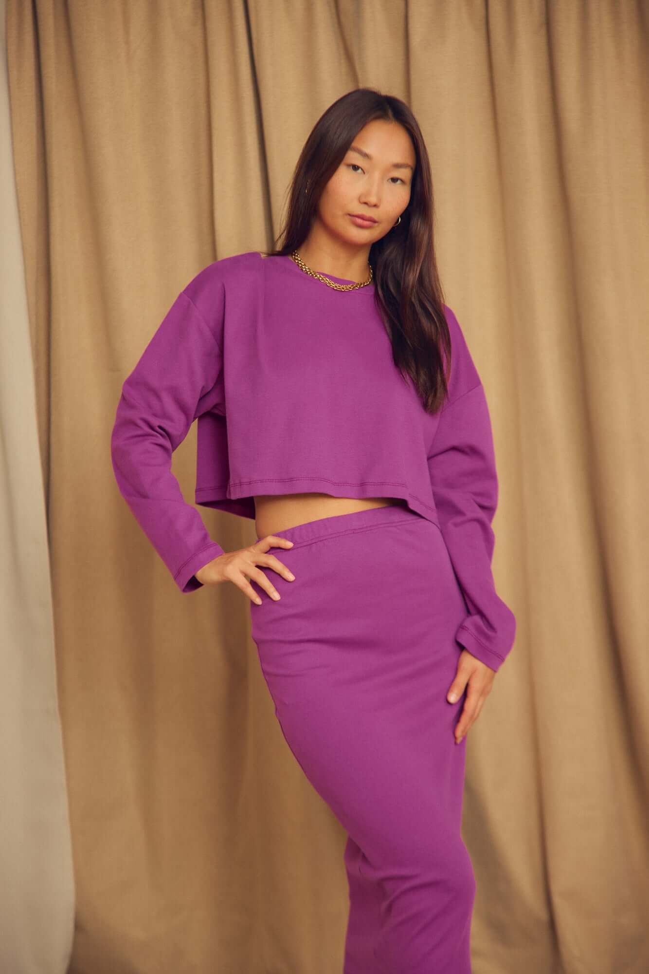 Model wearing Plum Organic Cotton Oversized Crop Top with matching skirt in a relaxed pose.
