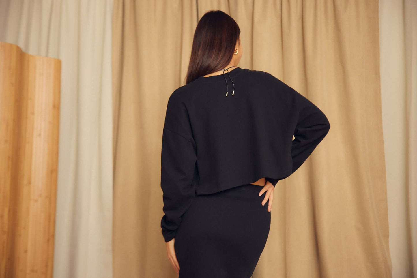 Model wearing Black Organic Cotton Oversized Crop Top, showcasing the relaxed fit and contemporary style from the back view.