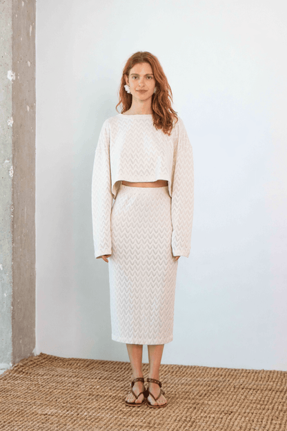 Crochet Organic Cotton Long Sleeve Top worn with matching skirt against a neutral background, showcasing its textured design.