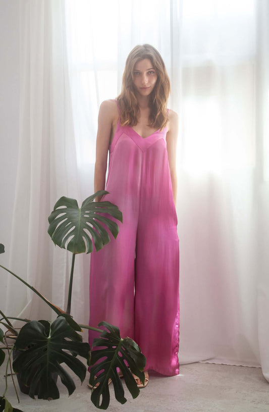 Model wearing a Printed Wide Jumpsuit in pink color, showcasing adjustable shoulder straps and side pockets.