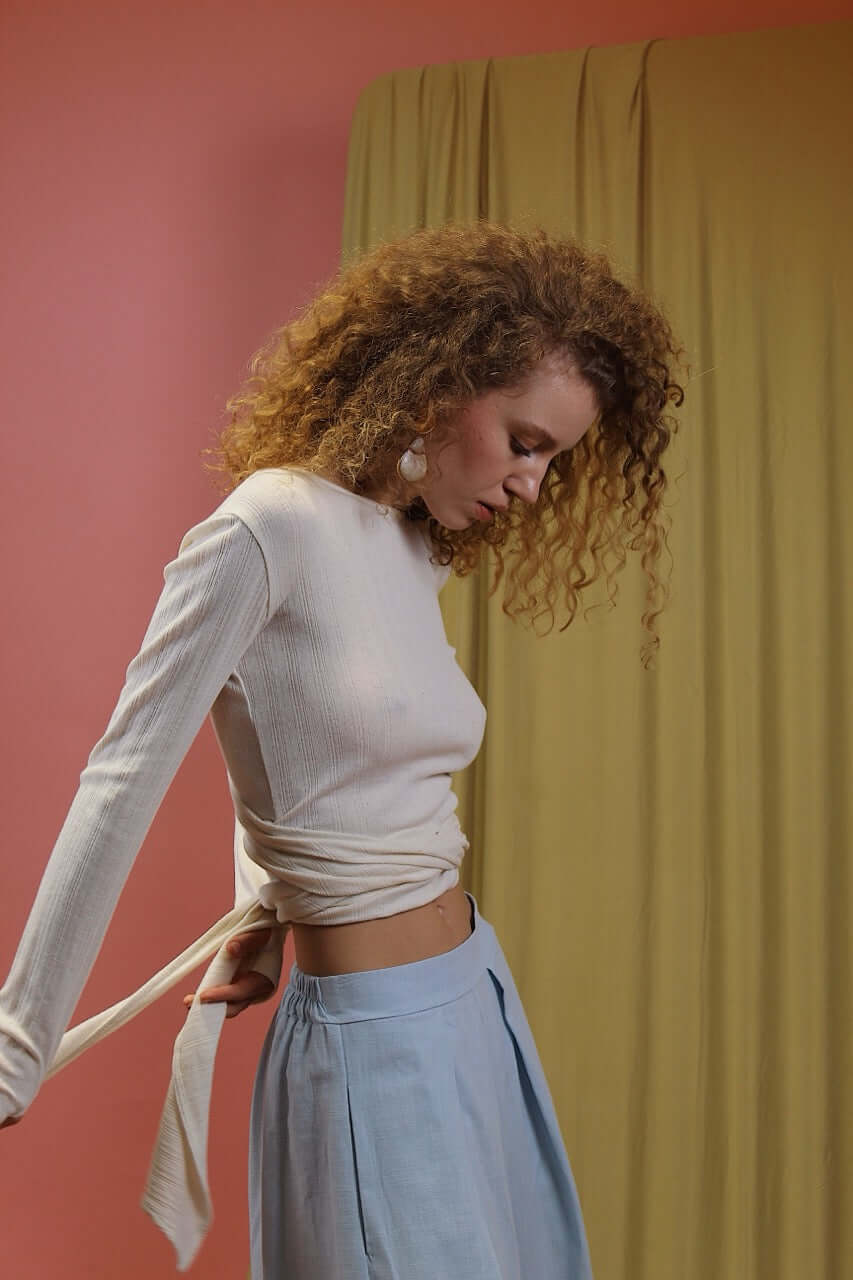 Banana Pineapple Multiway Wrap Top in Ecru worn by a model, showcasing its versatile wrap design and textured rib jersey.